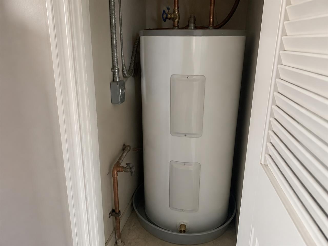 Electric tank water heater in a utility closet