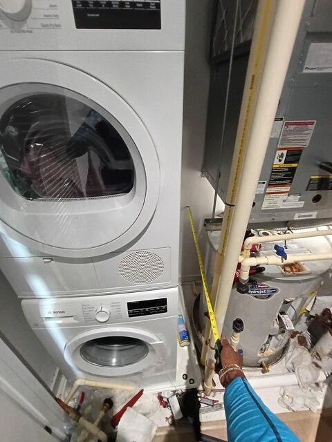 Electric water heater installed beside stacked laundry equipment in a Northeast Washington DC condominium